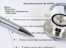 Un stéthoscope et un stylo posés sur un questionnaire médical - MACSF