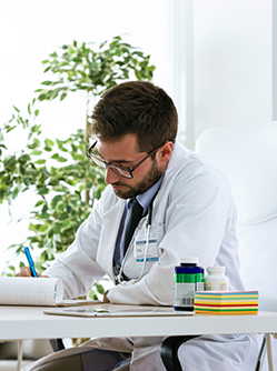 Un médecin prend des notes pendant sa consultation - MACSF
