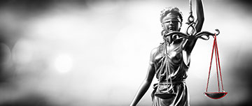 Une statuette de la justice argentée sur fond lumineux gris - MACSF