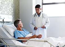 Un médecin écoute un patient alité à l'hôpital - MACSF