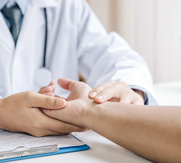 Un médecin examine le poignet de son patient - MACSF