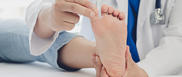 Le médecin ausculte le pied d'une patiente - MACSF