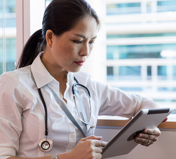 Une femme médecin regarde sa tablette - MACSF