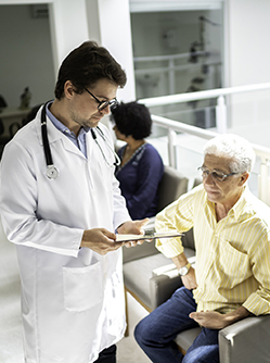 Un médecin discute avec un patient dans la salle d'attente de l'hôpital - MACSF