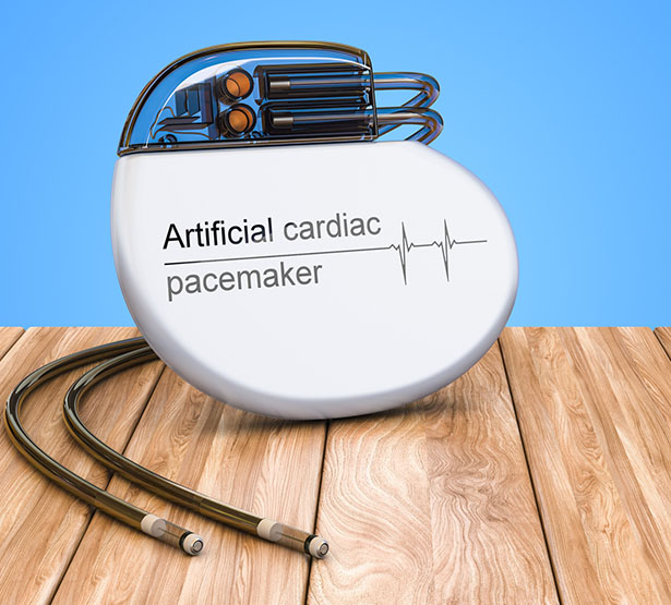 Stimulateur cardiaque artificiel posé sur une table en bois - MACSF