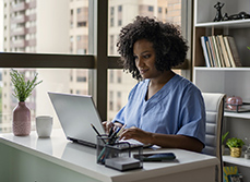 Une infirmière devant l'écran de son ordinateur - MACSF