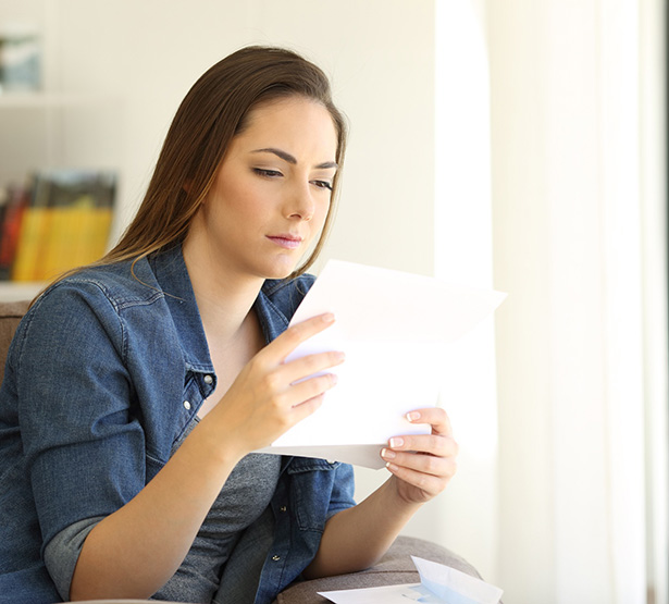 Une femme assise lit un courrier - MACSF