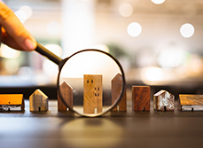 Représentation de 8 petites maisons en bois alignées et pointées par une loupe - MACSF
