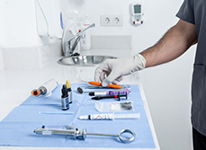 Le dentiste saisit un instrument sur la table - MACSF