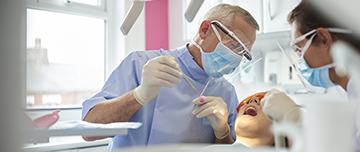 Un chirurgien-dentiste pratique des soins sur une patiente - MACSF
