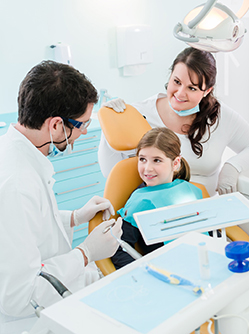 Dentiste en consultation avec une jeune patiente accompagnée de sa mère enceinte - MACSF