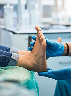 Un podologue examine les pieds d'un patient - MACSF