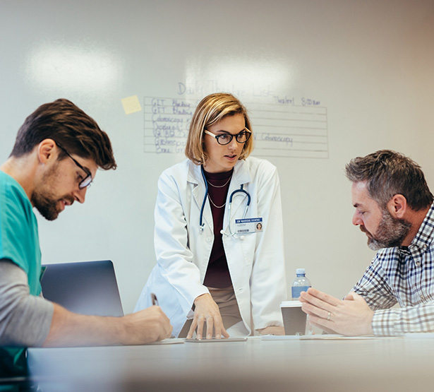 Trois soignants discutent d'un dossier à l'hôpital - MACSF