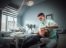 Un chirurgien-dentiste pratique des soins dentaires sur son patient - MACSF