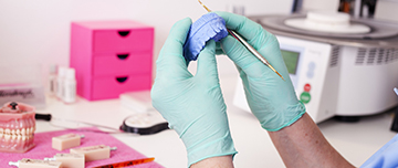 Gros plan sur les mains d'un épithésiste réalisant une prothèse - MACSF