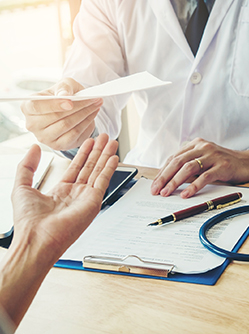 Un médecin remet un document à une patiente - MACSF