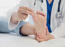 Le médecin ausculte le pied d'une patiente - MACSF