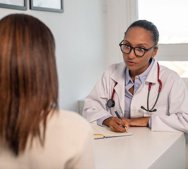 Une femme médecin face parle à une patiente assise au bureau - MACSF