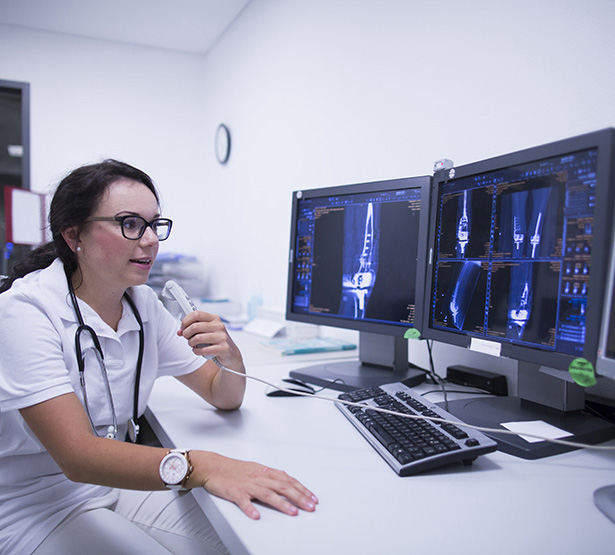 Une radiologue dicte un compte-rendu en visionnant les radios à l'écran - MACSF