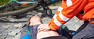 Un sauveteur fait un massage cardiaque a un cycliste accidenté - MACSF