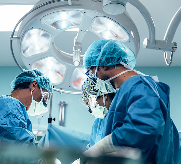 Une équipe chirurgicale vêtue de bleu penchée sur un patient - MACSF