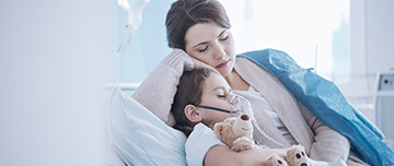 Une maman allongée à côté de son fils sur le lit de l'hôpital - MACSF