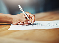 Main d'une personne écrivant sur un document - MACSF
