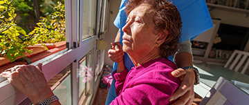 Une femme âgée assise près de la fenêtre avec la soignante - MACSF