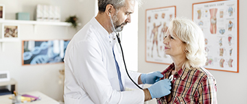 Un médecin écoute le coeur d'une d'une patiente avec son stéthoscope - MACSF