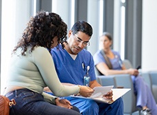 Un infirmier parle avec une patiente dans la salle d'attente de l'hôpital - MACSF