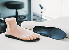 Un pied mannequin posé sur une semelle orthopédique noire - MACSF