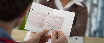 Un cardiologue observe l'ECG d'une patiente en consultation - MACSF