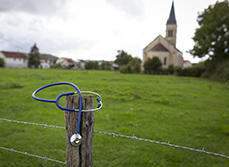 Un stéthoscope posé sur le poteau d'un pré avec la campagne en arrière-plan - MACSF