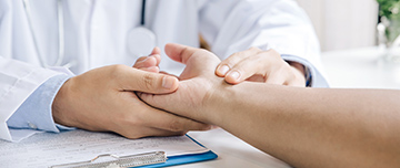 Un médecin examine le poignet de son patient - MACSF