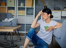 Une femme désabusée avec un smartphone dans la main - MACSF