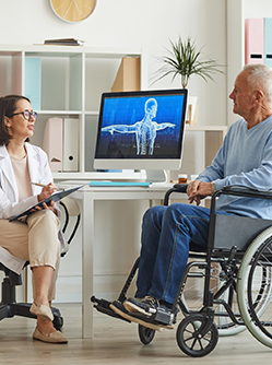 Une femme médecin en consultation avec une homme en fauteuil roulant - MACSF