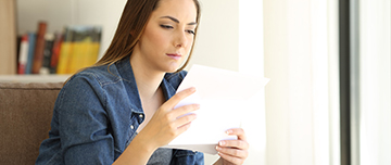 Une femme assise lit un courrier - MACSF