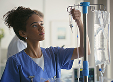 Une infirmière règle le débit d'une perfusion - MACSF