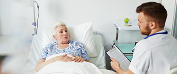 Un professionnel de santé discute avec une femme hospitalisée - MACSF