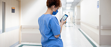 Une infirmière consultant son téléphone portable dans le couloir de l'hôpital - MACSF