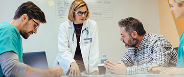 Quatre soignants discutent d'un dossier à l'hôpital - MACSF