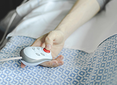 Un patient appuie sur le bouton d'appel dans son lit d'hôpital - MACSF