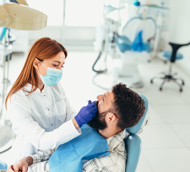 Une dentiste examine les dents des son patient - MACSF