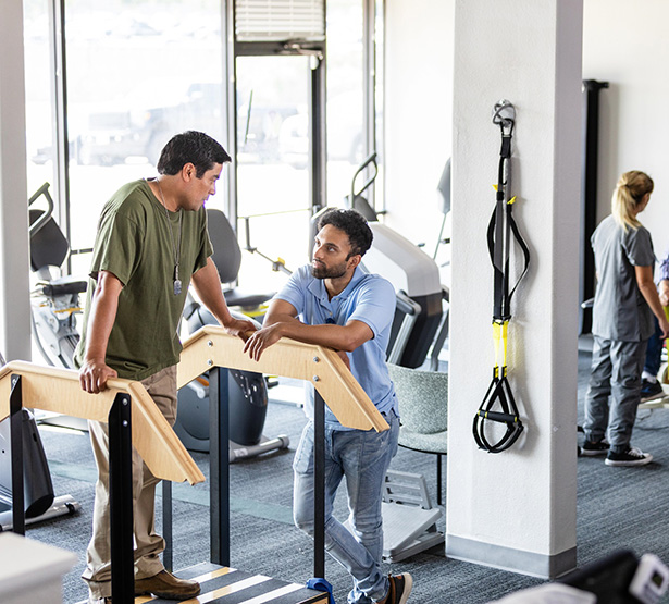 Des kinés discutent avec des patients dans une salle de rééducation - MACSF