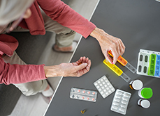 Gros plans sur les mains d'une femme âgée préparant son pilulier - MACSF