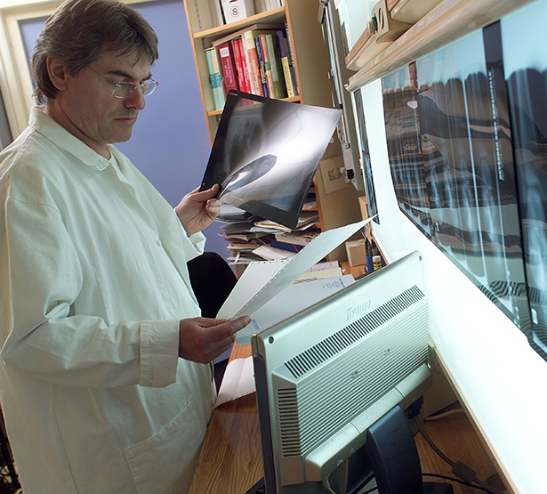 Un radiologue observe des clichés et des documents - MACSF