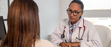 Une femme médecin face parle à une patiente assise au bureau - MACSF
