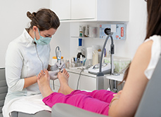 Une pédicure-podologue réalise des soins sur une patiente - MACSF