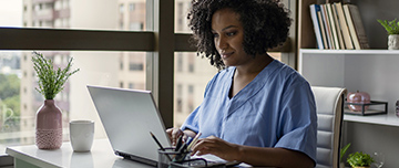 Une infirmière devant l'écran de son ordinateur - MACSF