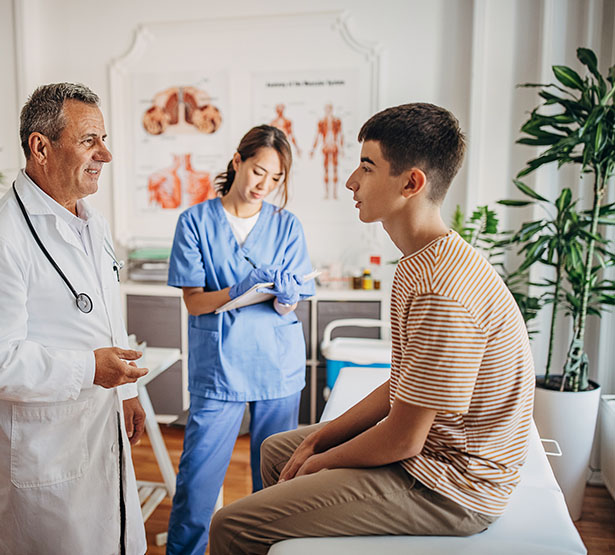 Un médecin discute avec un patient adolescent pendant qu'une infirmière prend des notes - MACSF
